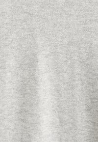 Textile tricoté gris clair, avec une texture lisse, présentant un motif uniforme subtil et une couture fine et régulière sur l'ensemble.