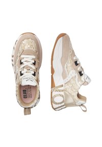 Beige sneakers with textured upper featuring sequins, rubber sole, and white laces. Notable black and gold accents on side and heel.