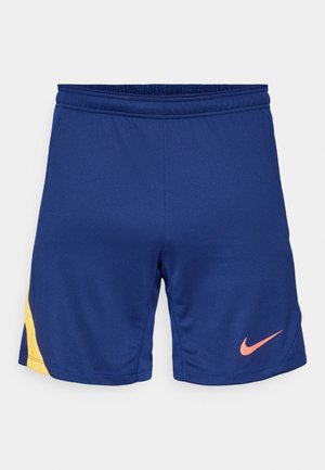 Shorts de sport bleu marine avec un détail latéral jaune et un logo Swoosh Nike rose sur la jambe droite, taille élastique.