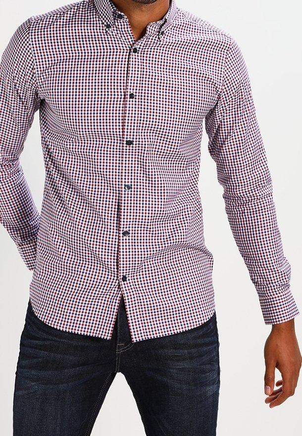 Červená a tmavě modrá károvaná košile s dlouhými rukávy, střihem na míru a černými knoflíky; kombinovaná s tmavými džínami.