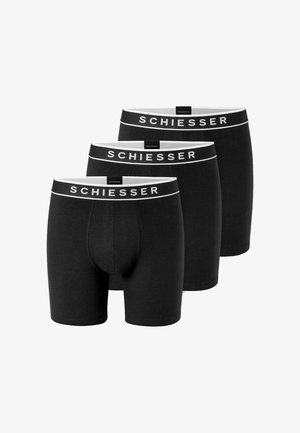Trois boxers noirs pour hommes avec des ceintures blanches affichant le nom de la marque Schiesser en lettres blanches.