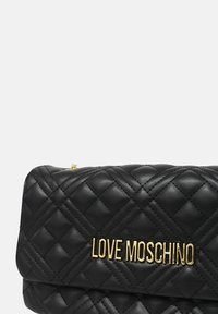 Borsa in ecopelle nera trapuntata con logo dorato "LOVE MOSCHINO", design a patta e dettagli di cuciture sottili.