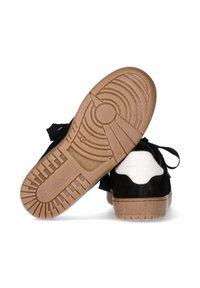 Sneaker bianco e nero con tomaia in suede testurizzato, chiusura con lacci e suola in gomma marrone con un motivo a battistrada circolare.