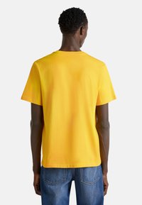Korte mouwen gele T-shirt met een ronde hals, gladde katoen stof, ontspannen pasvorm en geen zichtbare patronen of accenten.