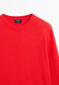 Jasnoczerwony sweter z kaszmiru z okrągłym dekoltem i prążkowanym kołnierzem, oznaczony marką Massimo Dutti, prezentowany na białym tle.