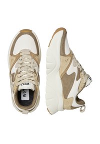 Sneaker beige e bianchi con dettagli in suede, tessuto texture e suola in gomma spessa. Presentano un design con lacci e un'apertura per il passaggio del piede.