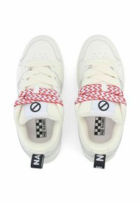 Baskets blanches avec une tige en cuir et en mesh, lacets rouge et blanc en zigzag, languette rembourrée et patch arrière noir contrastant. Logo à damier sur la languette.