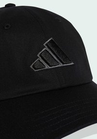 Black cap made of textured fabric featuring a raised, embroidered three-stripe logo in dark gray. Structured design with a curved brim.
