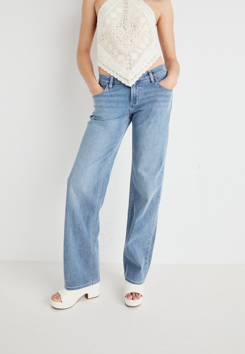 Light blue, wide-leg jeans in denim with a smooth texture, featuring front pockets and a classic five-pocket design.