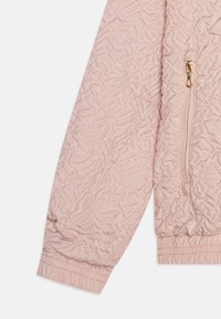 Casaco rosa claro com fecho éclair, textura enrugada, punhos elásticos e um bolso lateral com acabamentos em tom de ouro.