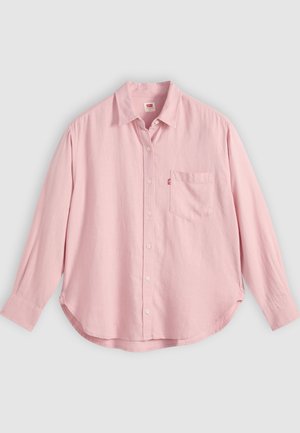 Cămașă roz deschis cu mâneci lungi, nasturi și buzunar la piept, așezată pe o suprafață plată, pe un fundal gri.