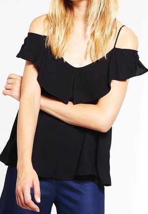 Černý top odhalený na ramenou s volánkovými rukávy, jemným výstřihem do V a volným střihem. Lehká látka, hladká textura bez výrazných vzorů.