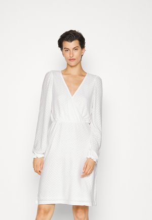 Vestido branco com decote em V, mangas bufantes longas e tecido texturizado. Apresenta uma cintura elástica e punhos franzidos para um ajuste confort�ável.