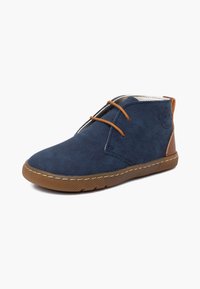 Stivali alla caviglia in tessuto blu navy con accenti in pelle marrone, punta tonda e cuciture a contrasto. Presentano lacci marroni e superficie texture.