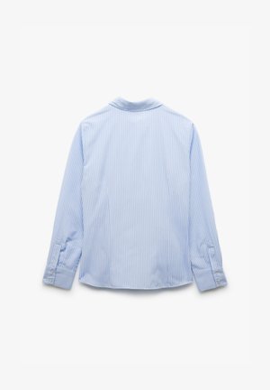 Jasnoniebieska koszula z długim rękawem w pionowe białe paski. Posiada klasyczny kołnierzyk i mankiety na guziki. Gładka tekstura materiału.
