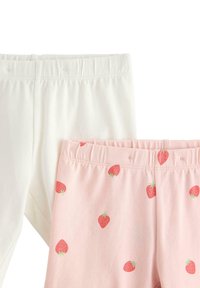 Kaksi paria legginssejä: yksi täysin valkoinen, toinen vaaleanpunainen, jossa on toistuva mansikkakuosi. Molemmissa on joustava vyötärö ja pehmeä kangas.