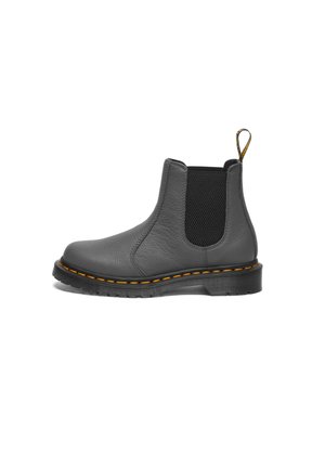 Botín de cuero gris hasta el tobillo con lados elásticos, costuras amarillas y una lengüeta. Presenta un upper texturizado y una suela de goma resistente.