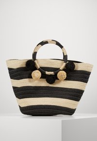 Borsa tote intrecciata a righe in nero e beige, dotata di manici rotondi e pompon decorativi in colori nero e naturale. Finitura texturizzata.