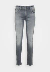 Jeans ajustados de mezclilla, en un color gris medio con un leve desgastado. Cuenta con cinco bolsillos y cierre de botón.