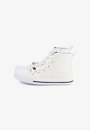 Baskets montantes en toile à paillettes blanches, avec un bout en caoutchouc et des détails en rayures noires. Dotées de lacets blancs et de languettes de talon à boucle.