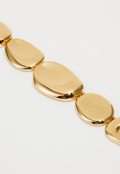 Collier en métal doré avec des maillons lisses et en forme d'ovale. Chaque maillon a une finition brillante, réfléchissant la lumière et créant un design homogène.