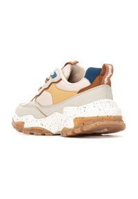 Zapatillas chunky en beige, marrón y azul. Cuenta con una suela blanca moteada, superposiciones texturizadas y una lengüeta en marrón con el logotipo de la marca.