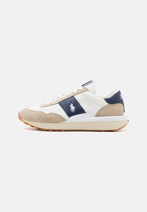 Sapatilhas masculinas com parte superior em couro branco, com detalhes em camurça azul-marinho e bege, fecho com atacadores planos e sola de borracha off-white.