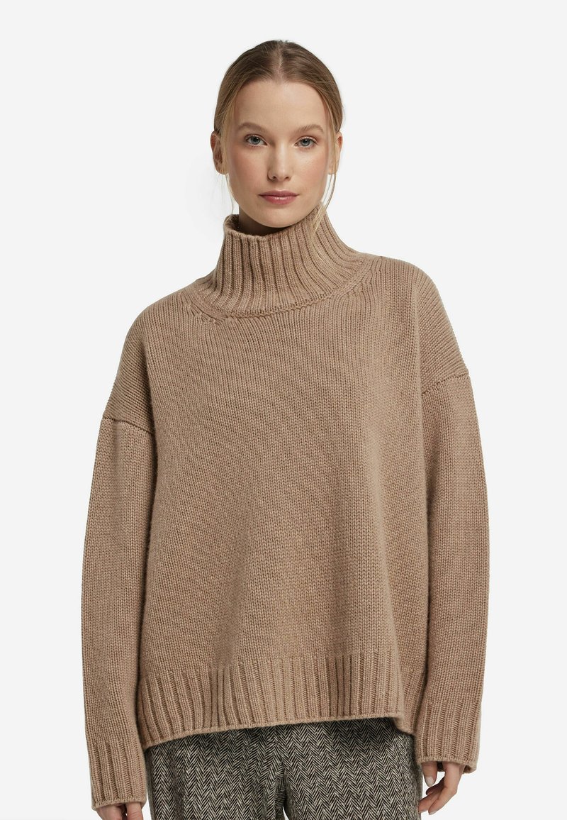 Jasnobrązowy, oversize sweter z golfem, z prążkowanym dekoltem i hemem. Teksturowana dzianina, luźny krój, z obniżonymi ramionami.