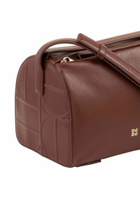 Borsa in pelle marrone con forma rotonda, motivo geometrico a rilievo, accessori in oro e manico corto, che mette in evidenza una texture liscia.