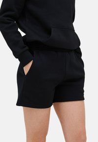 Schwarze Baumwollmischung-Shorts mit einem elastischen Bund und seitlichen Taschen. Sanfte Textur, einfaches Design und Saumabschlüsse.