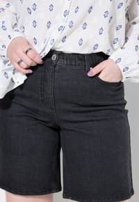 Zwarte denim shorts met een medium hoge taille, voorzien van een voorste knoopsluiting, een vijf-pocket ontwerp en subtiele stikseldetails.