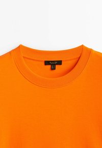 T-shirt in cotone arancione con colletto rotondo e a coste, dalla texture liscia e priva di motivi o dettagli visibili.