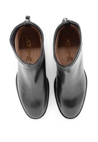 Stivaletti in pelle nera con finitura liscia, punta tonda e chiusura con zip sul retro. All'interno presenta una soletta marrone con logo.