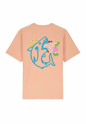 Pfirsichfarbener Baumwoll-T-Shirt mit einem bunten Druck eines Hais, der von einer Sonne und lebhaften Elementen umgeben ist, in Blau, Pink und Grün gestickt.