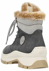 Botte grise avec un dessus en tissu texturé, un revers en fausse fourrure, des lacets argentés et une semelle épaisse blanche et beige. Détail du logo sur le côté.