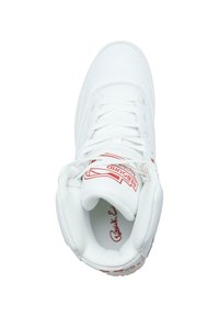 Baskets montantes blanches avec texture perforée, lacets blancs plats et un logo rouge sur la languette. Semelle en caoutchouc avec accents texturés.