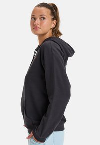 Schwarzer Kapuzenpullover mit einer vorderen Kängurutasche, Kordelzugkapuze und gerippten Bündchen. Weicher Stoff, der sich durch minimalistische Designelemente auszeichnet.