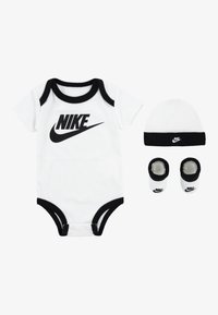 Une combinaison courte blanche à manches courtes avec des accents noirs, ornée d'un grand logo Nike noir. Comprend un bonnet assorti et une paire de chaussons.
