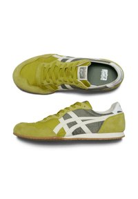 Sneaker in suede verde con dettagli bianchi; presenta una parte superiore testurizzata, chiusura con lacci e una suola in gomma per un'ottima trazione.