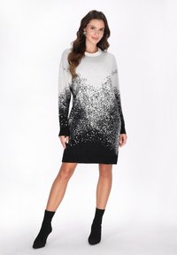 Rochie tricotată cu un gradient de la gri deschis la negru, având o textură cu modele și mâneci lungi. Sosete negre până la gleznă.