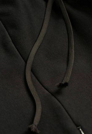 Schwarzer Hoodie-Stoff mit zwei dunklen geflochtenen Kordeln und einem Reißverschluss. Glatte Textur mit dezenten Nahtdetails entlang der Kanten.