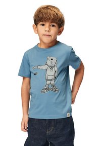 Sininen puuvillapaita, jossa on painettu grafiikka huppupaitaan pukeutuneesta karhusta, yhdistettynä tummansinisiin farkkuihin. Normaali malli ja lyhyet hihat.