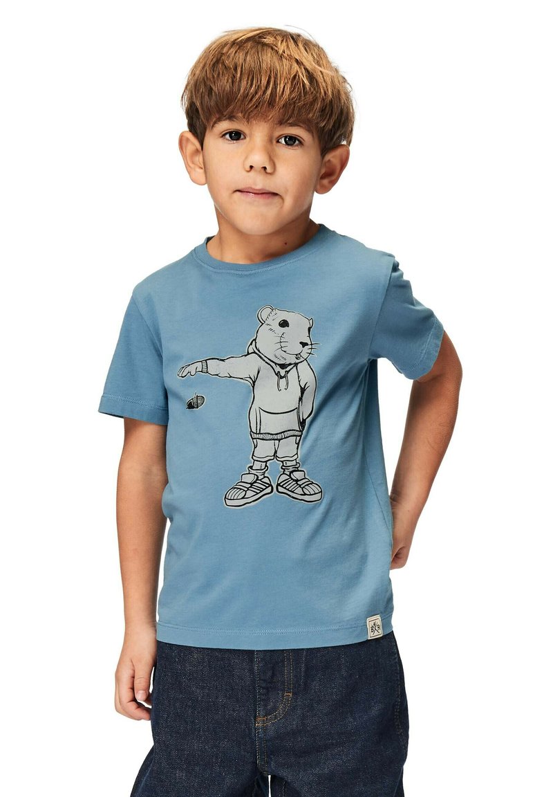 Sininen puuvillapaita, jossa on painettu grafiikka huppupaitaan pukeutuneesta karhusta, yhdistettynä tummansinisiin farkkuihin. Normaali malli ja lyhyet hihat.