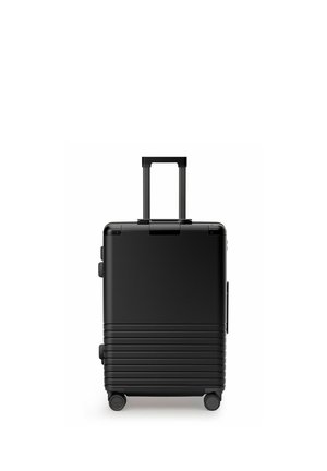 Schwarzer Hartschalen-Handgepäckkoffer mit ausgezogenem Teleskopgriff und vier Drehrollen auf weißem Hintergrund.