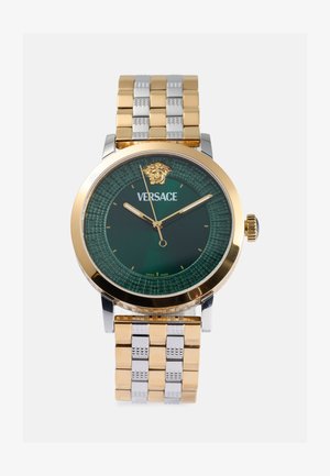 Reloj Versace con esfera verde, acentos en tono dorado y pulsera metálica bicolor. Presenta un detalle de la cabeza de Medusa en la posición de las 12 en punto.