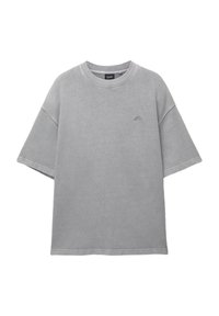 Šedé oversized tričko vyrobené z bavlny, s okrúhlym výstrihom, krátkymi rukávmi a malým logom na hrudi s textúrovaným povrchom.