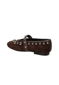 Scarpe piatte in suede marrone con punta arrotondata, cinturino sulla parte superiore e borchie metalliche lungo il bordo e il cinturino. Suola piatta.