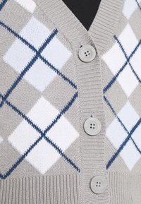 Harmaa argyle-tyylinen villapaita, jossa on valkoisia ja tummansinisiä timantteja, ribbikuvioitu pinta sekä kolme harmaata nappia, joissa on kaiverrettuna "Hollister".