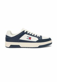 Baskets basses blanches et bleu marine avec lacets sur le devant, semelle en caoutchouc, et logo Tommy Jeans sur le côté et la semelle.