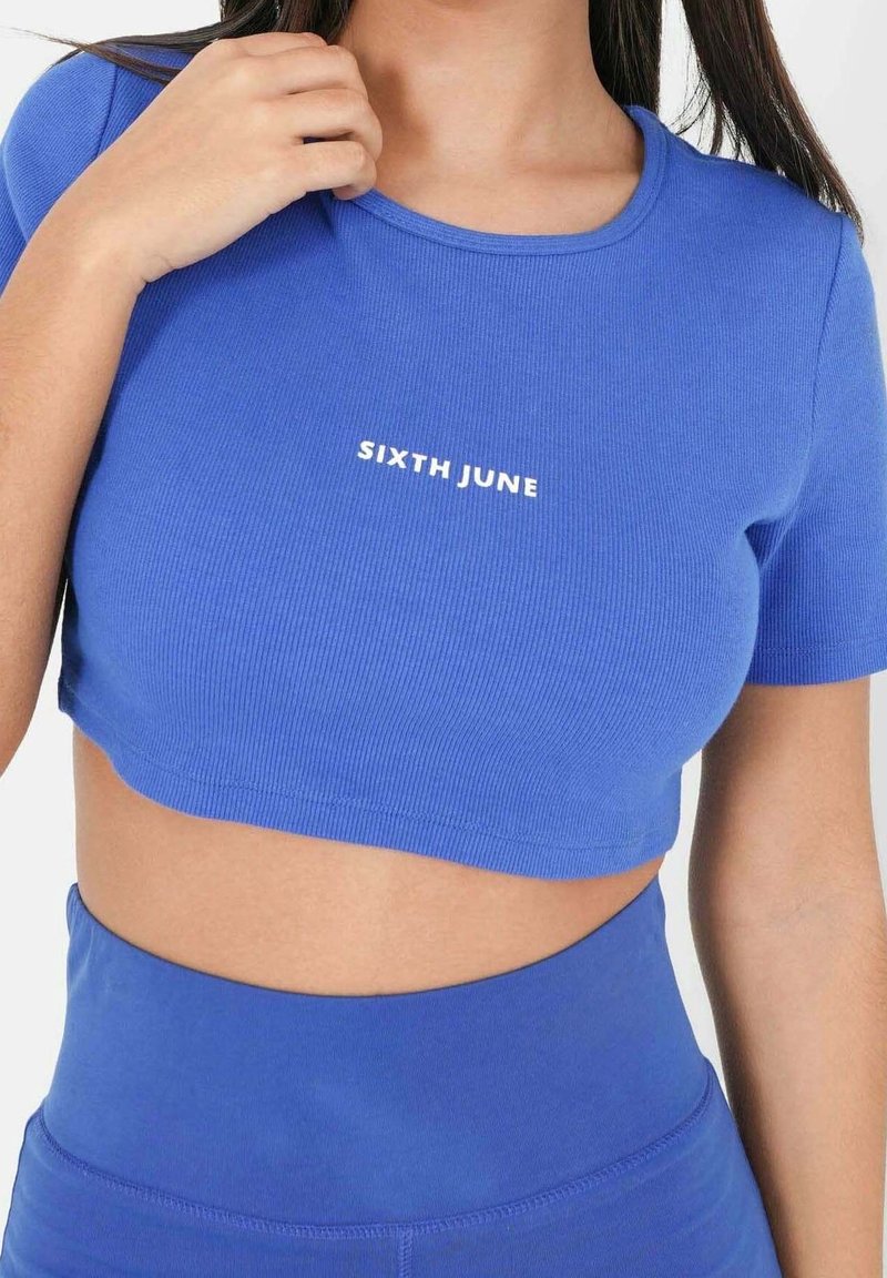 T-shirt court bleu à côtes avec manches courtes et encolure ronde, avec l'inscription "SIXTH JUNE" imprimée en blanc sur le devant.